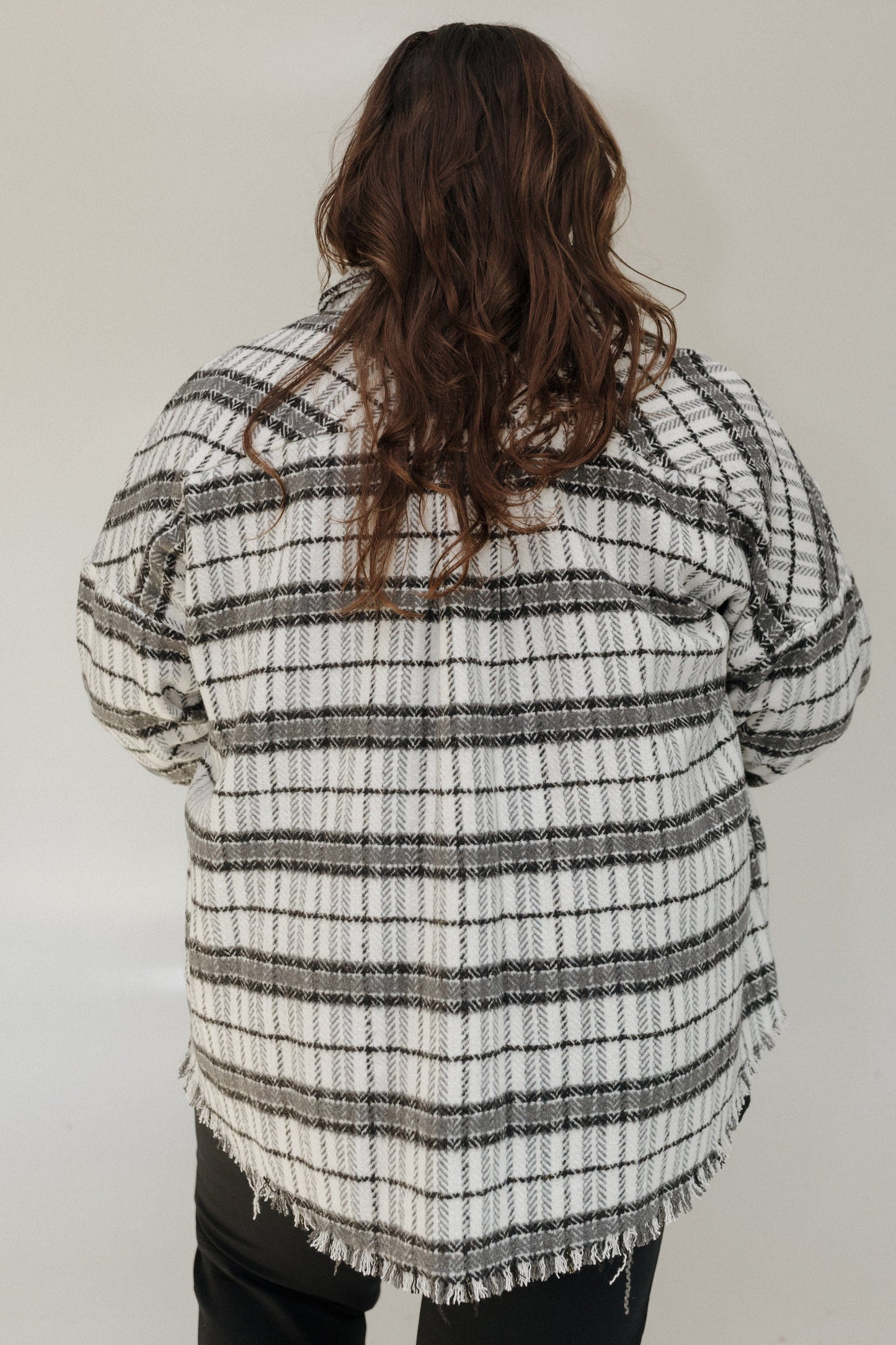 Person wearing a plaid shirt with a white background