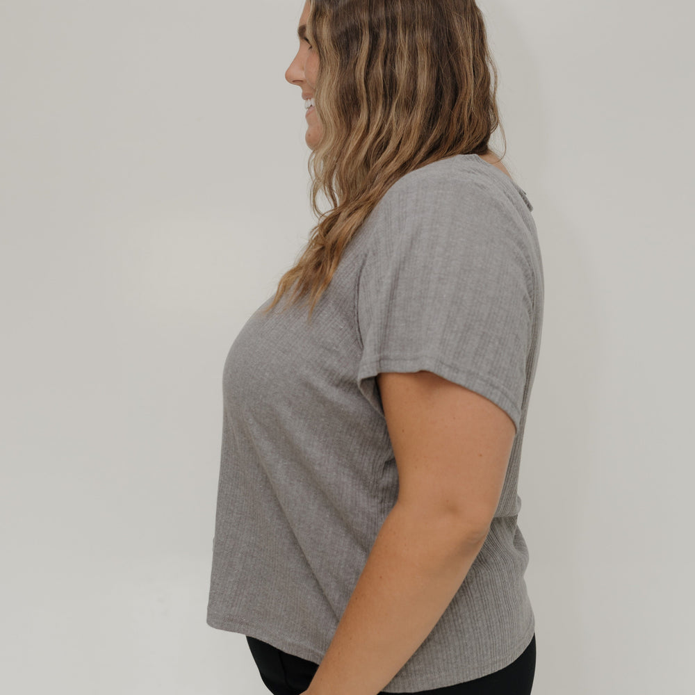 Woman wearing a gray t-shirt against a white background