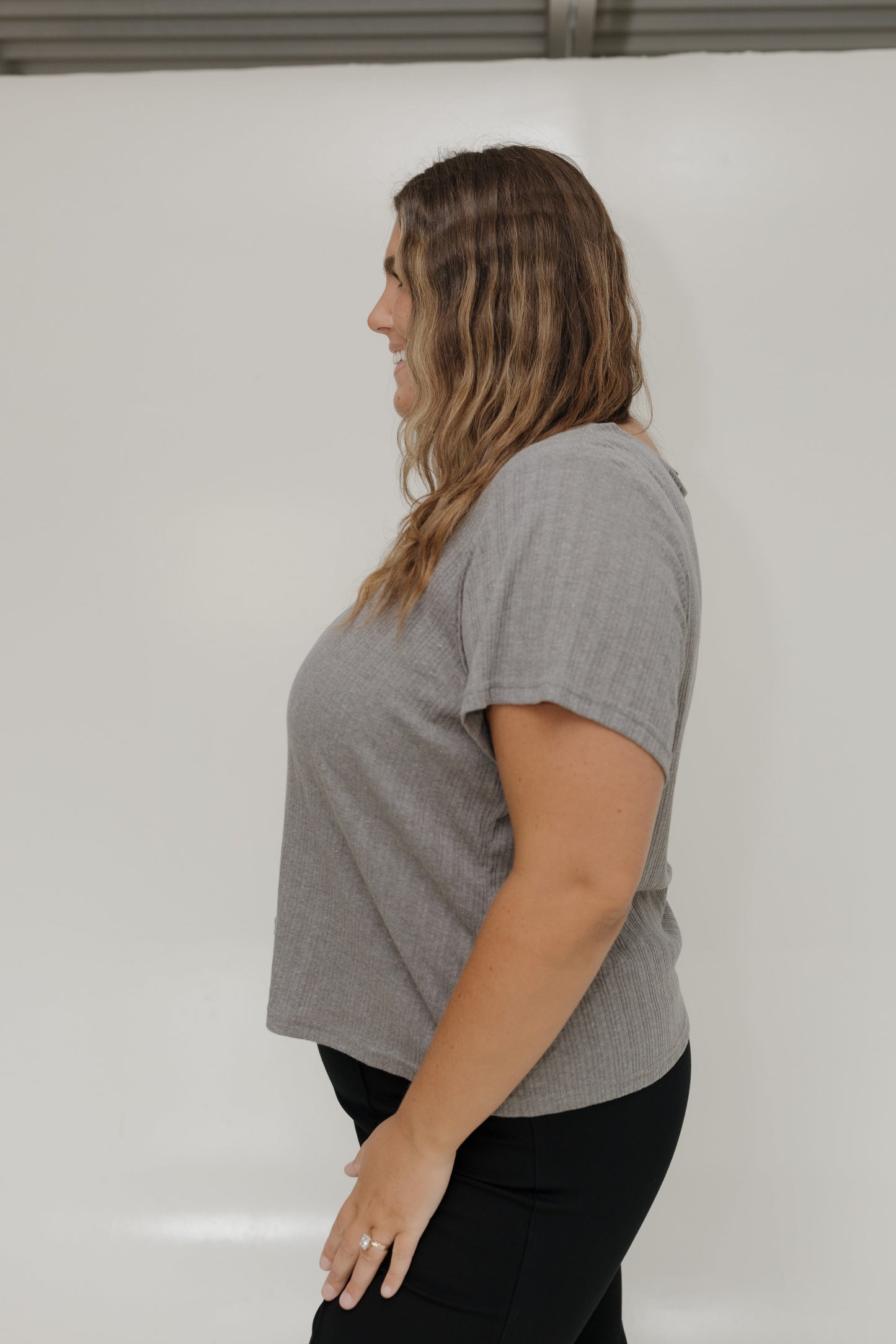 Woman wearing a gray t-shirt against a white background
