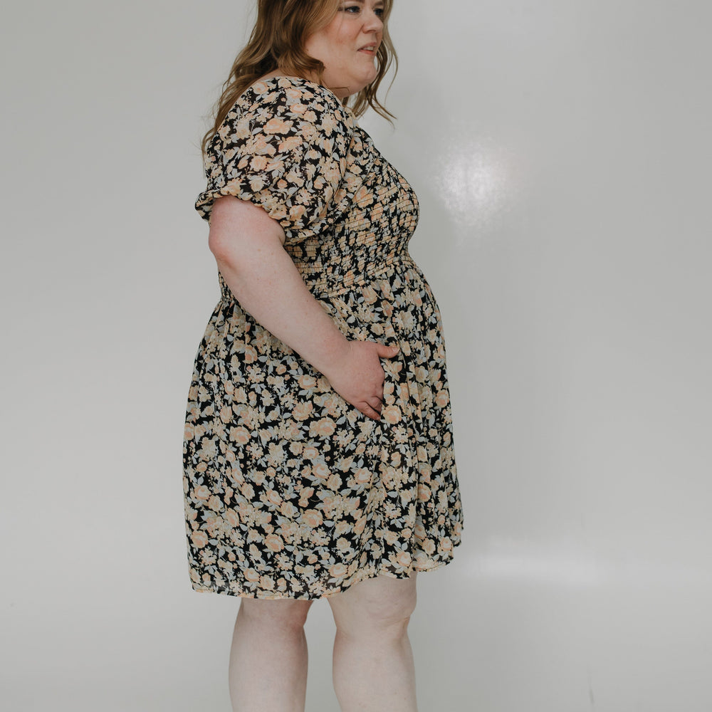 Woman wearing a floral dress on a plain background