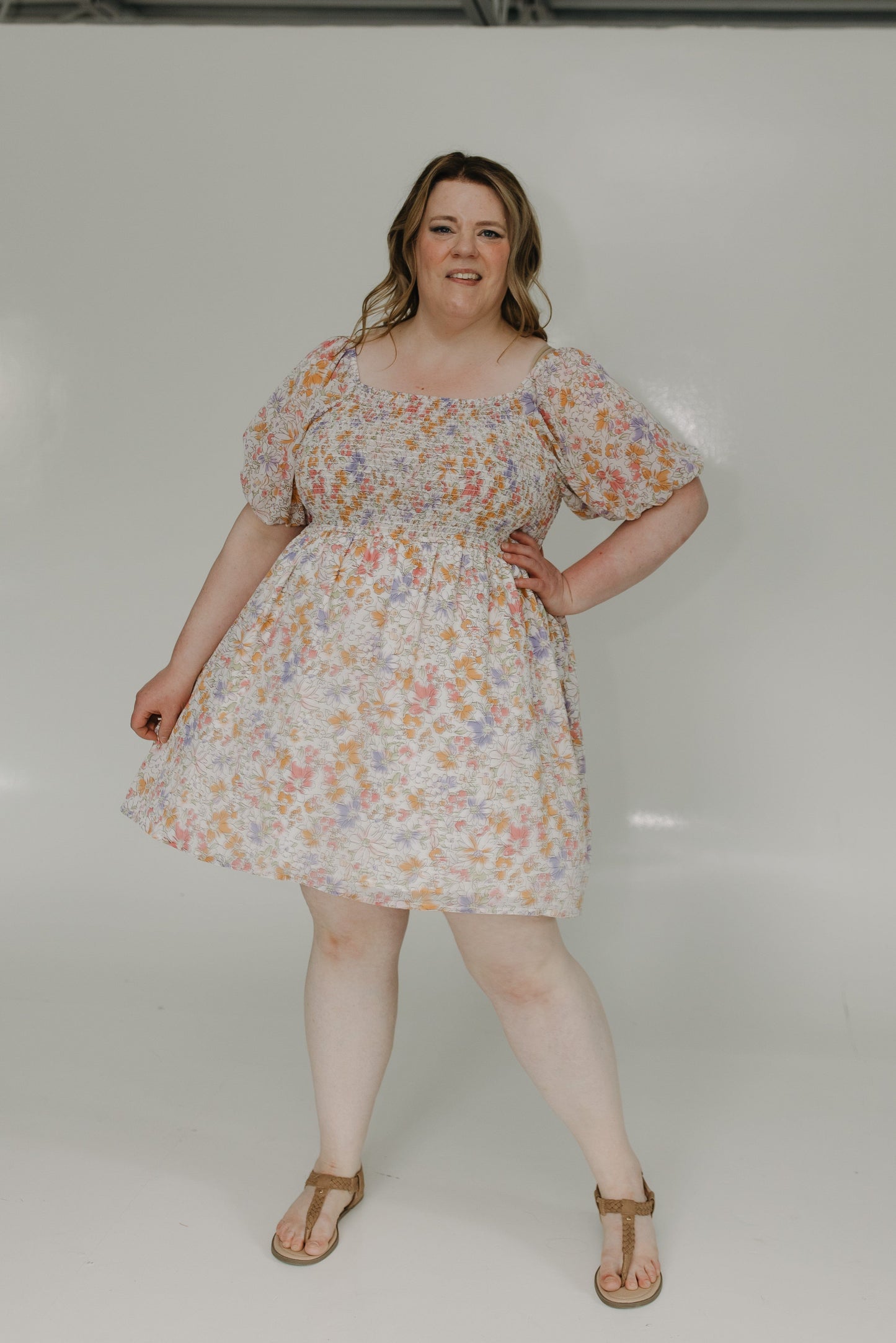 Woman wearing a floral dress against a white background