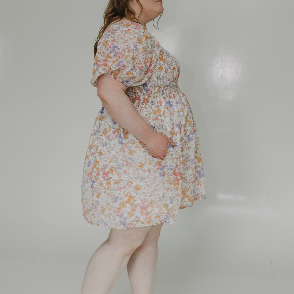 Woman wearing a floral dress on a plain background