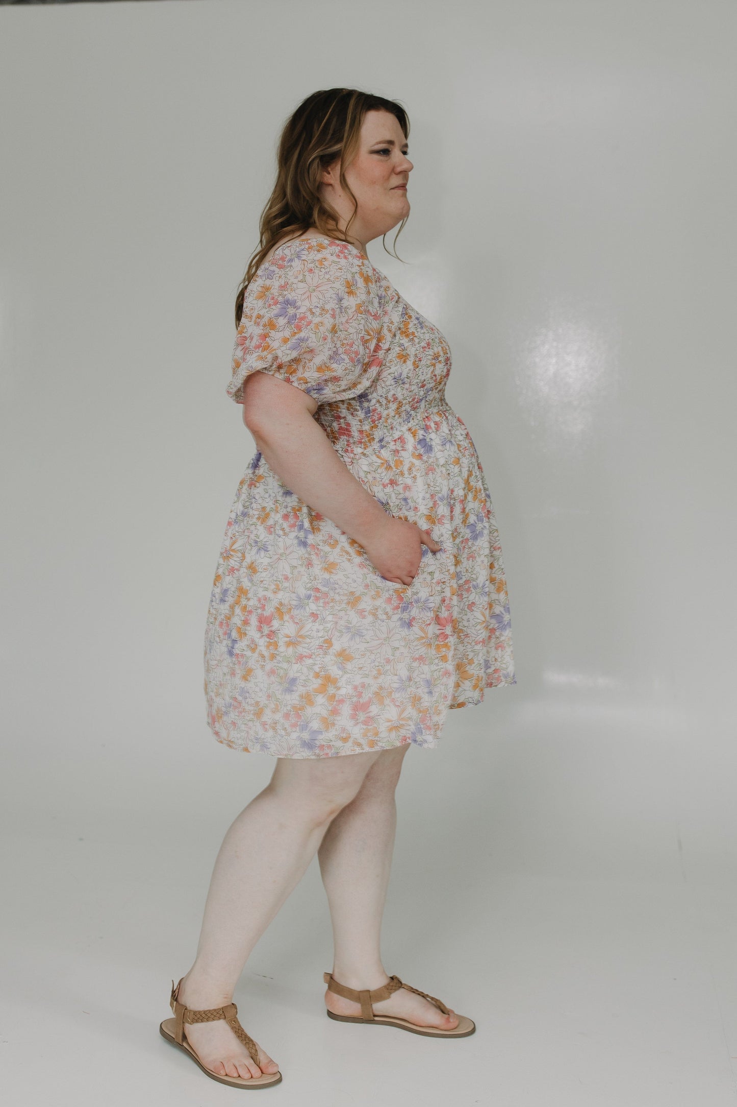 Woman wearing a floral dress on a plain background