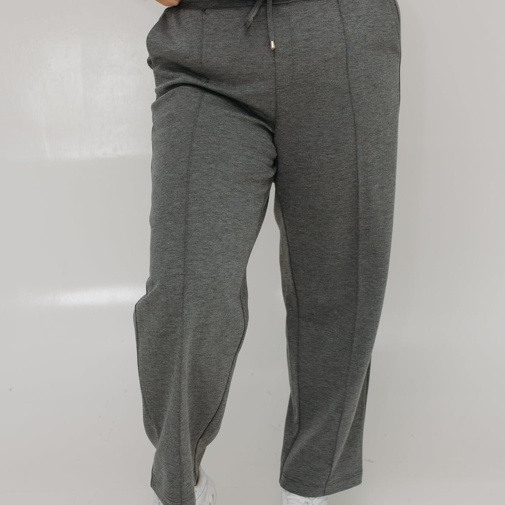 Person wearing gray sweatpants and a purple tie-dye hoodie on a white background