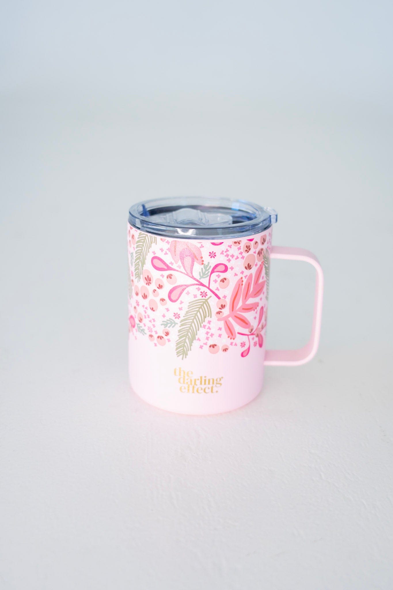 Pink tumbler with floral design on a light gray background
