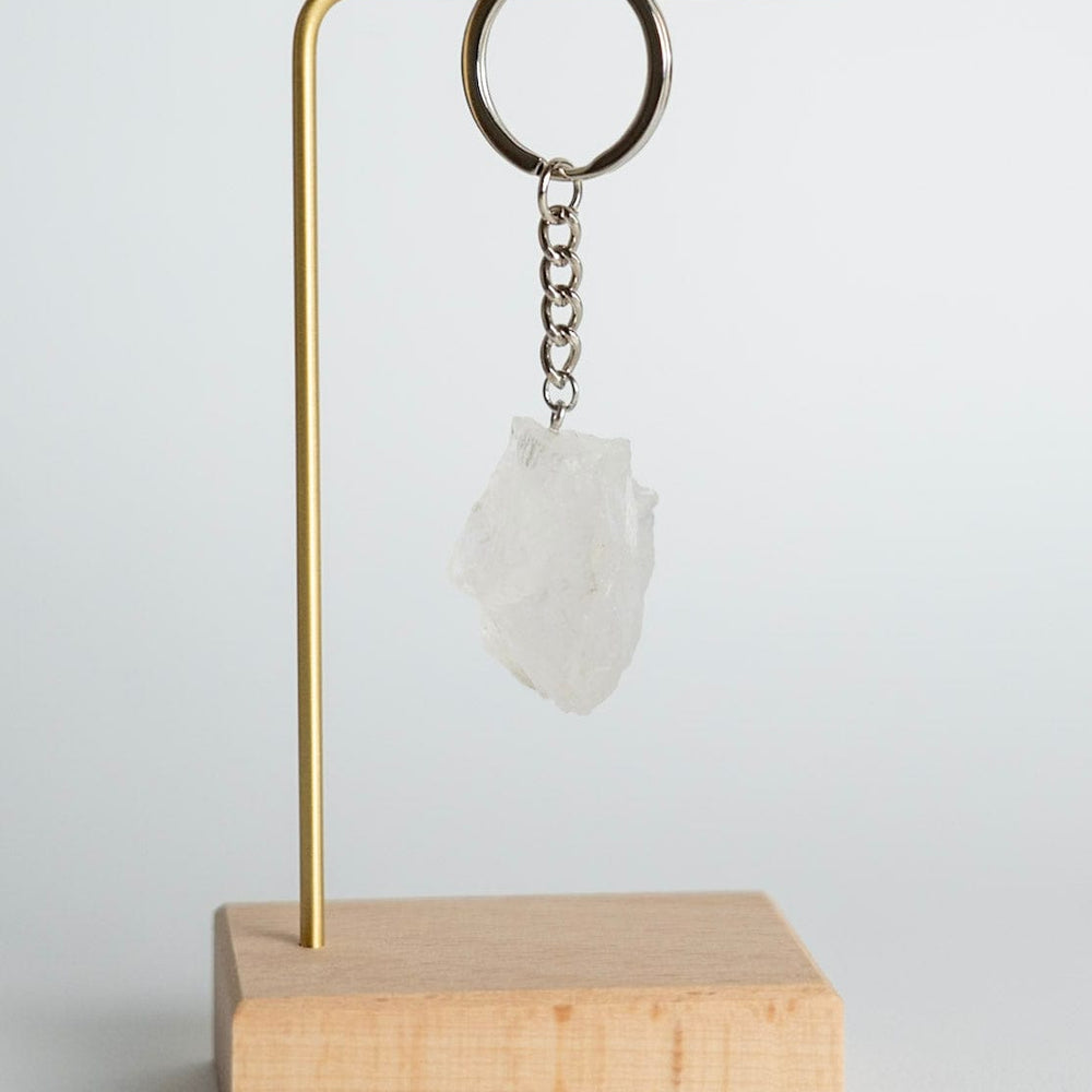 Quartz Keychain on a stand with a wooden base against a white background