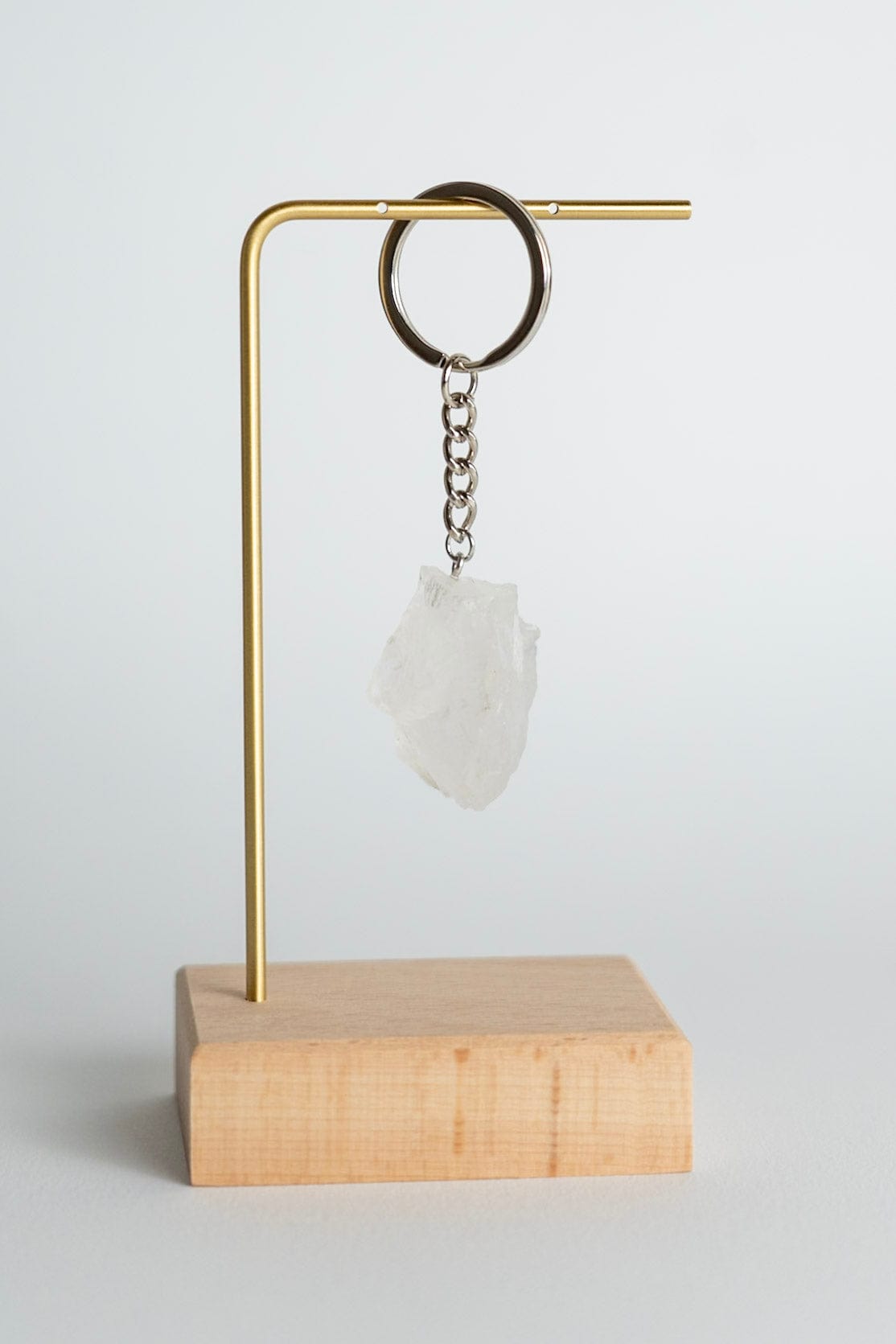 Quartz Keychain on a stand with a wooden base against a white background