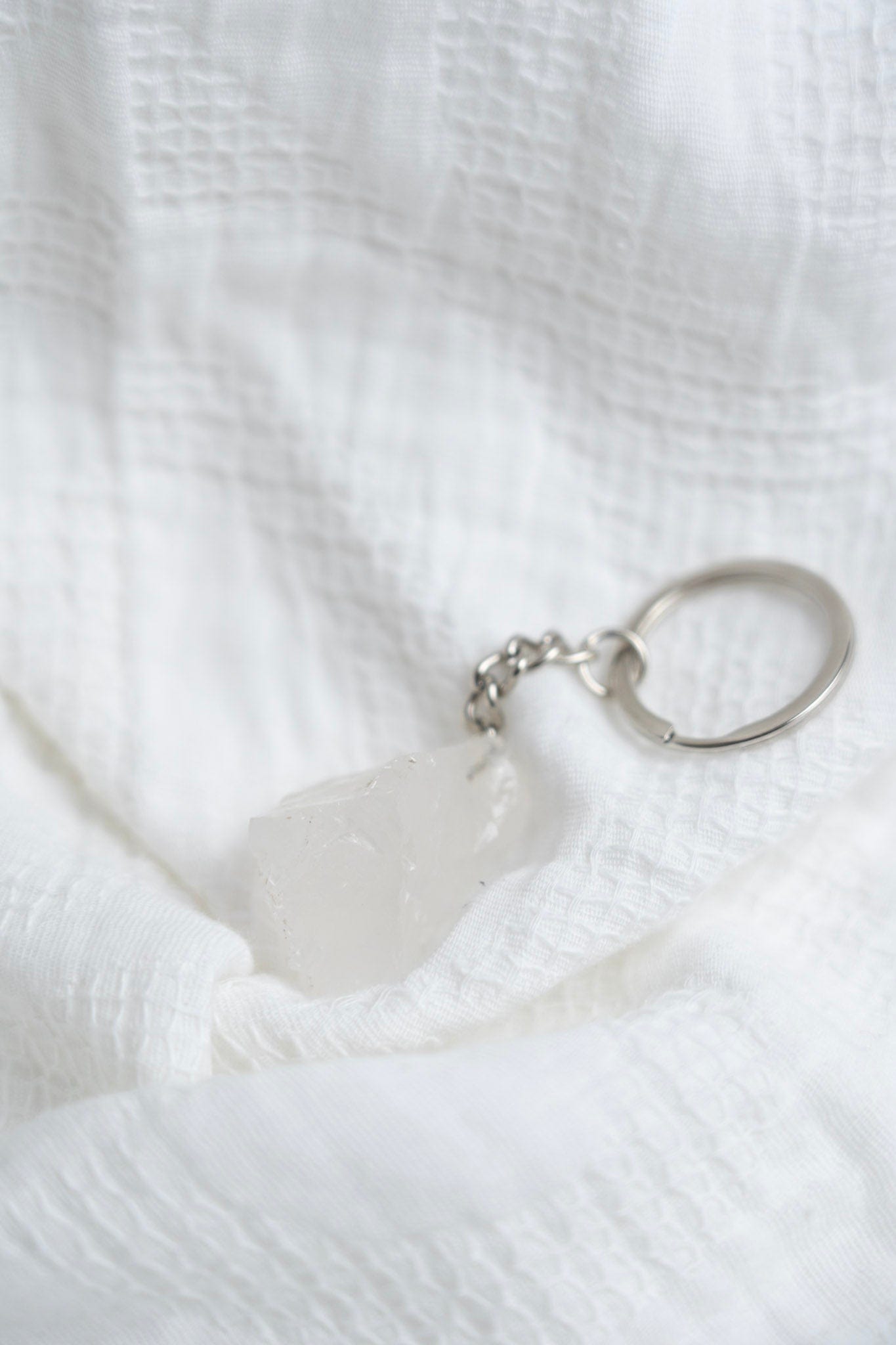 Close-up of a quartz keychain on a white textured fabric