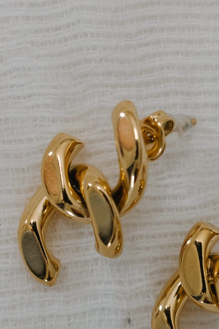 Gold hoop earrings on a textured white background