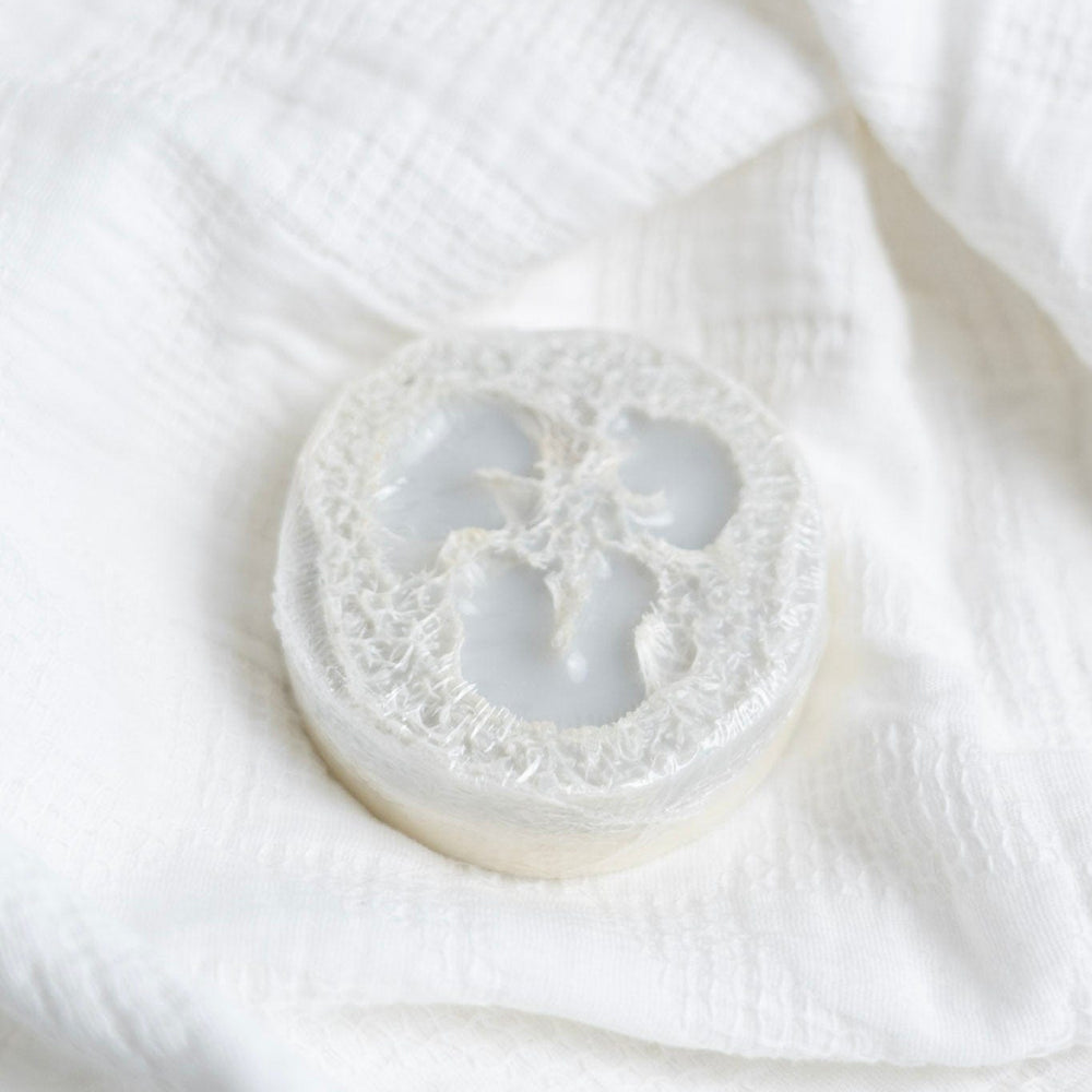 Rejuvenate loofah soap on a white fabric background