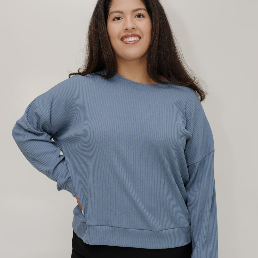 Woman wearing a blue sweater against a plain background
