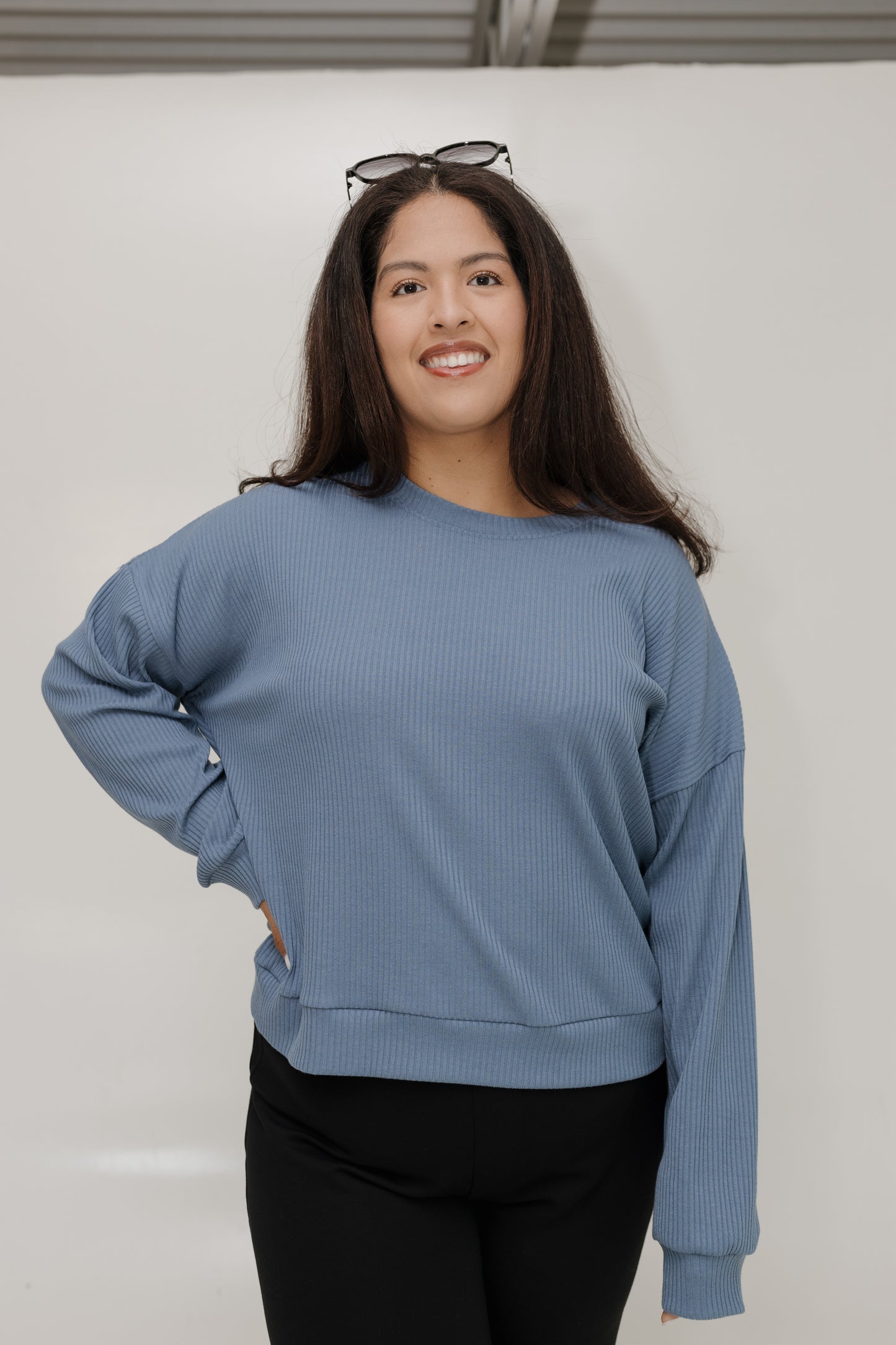 Woman wearing a blue sweater against a plain background