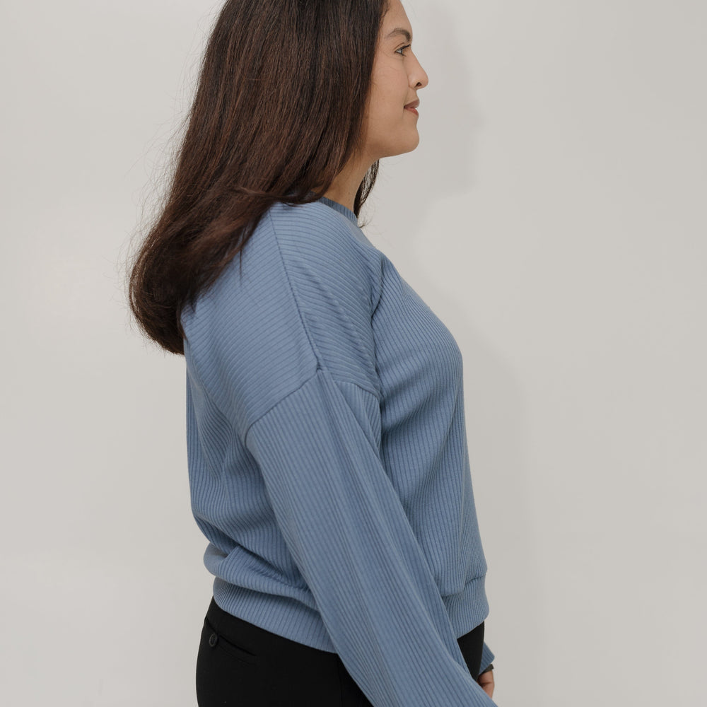Woman wearing a blue sweater against a white background