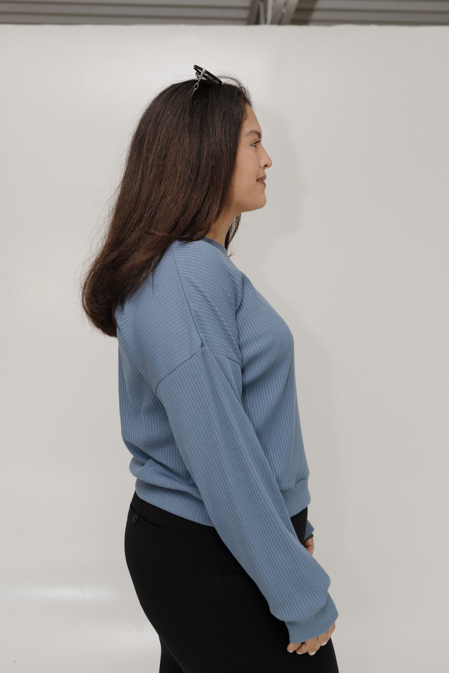 Woman wearing a blue sweater against a white background