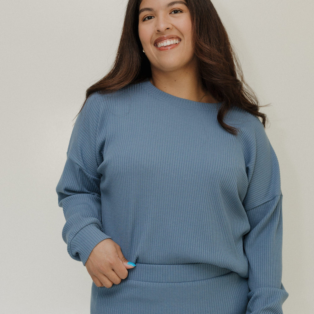 Woman wearing a blue outfit against a plain background