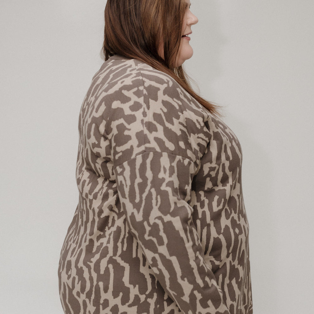 Woman wearing a patterned jacket against a plain background