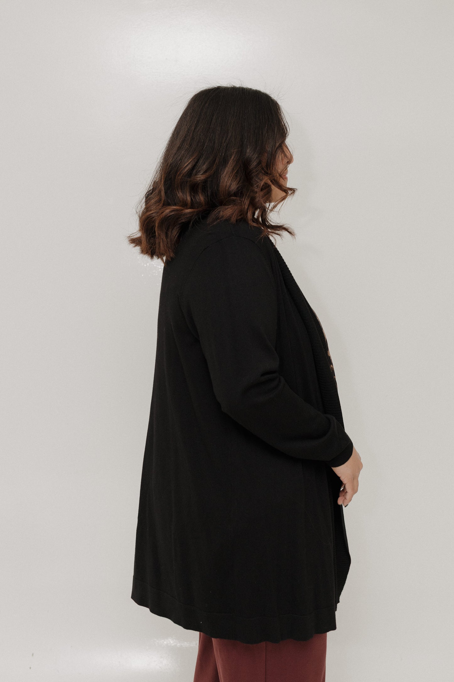 Woman wearing a black coat against a white background