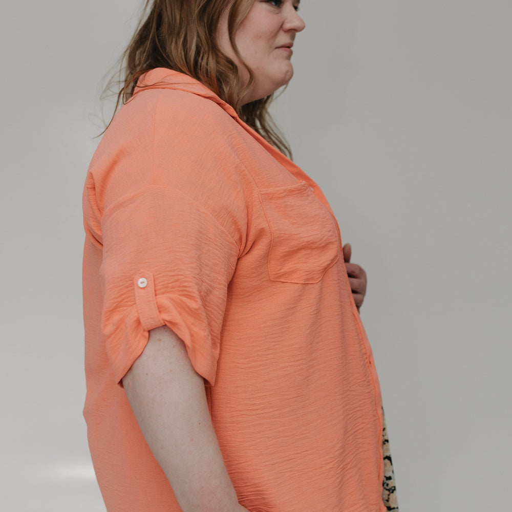 Woman wearing an orange shirt with a neutral background