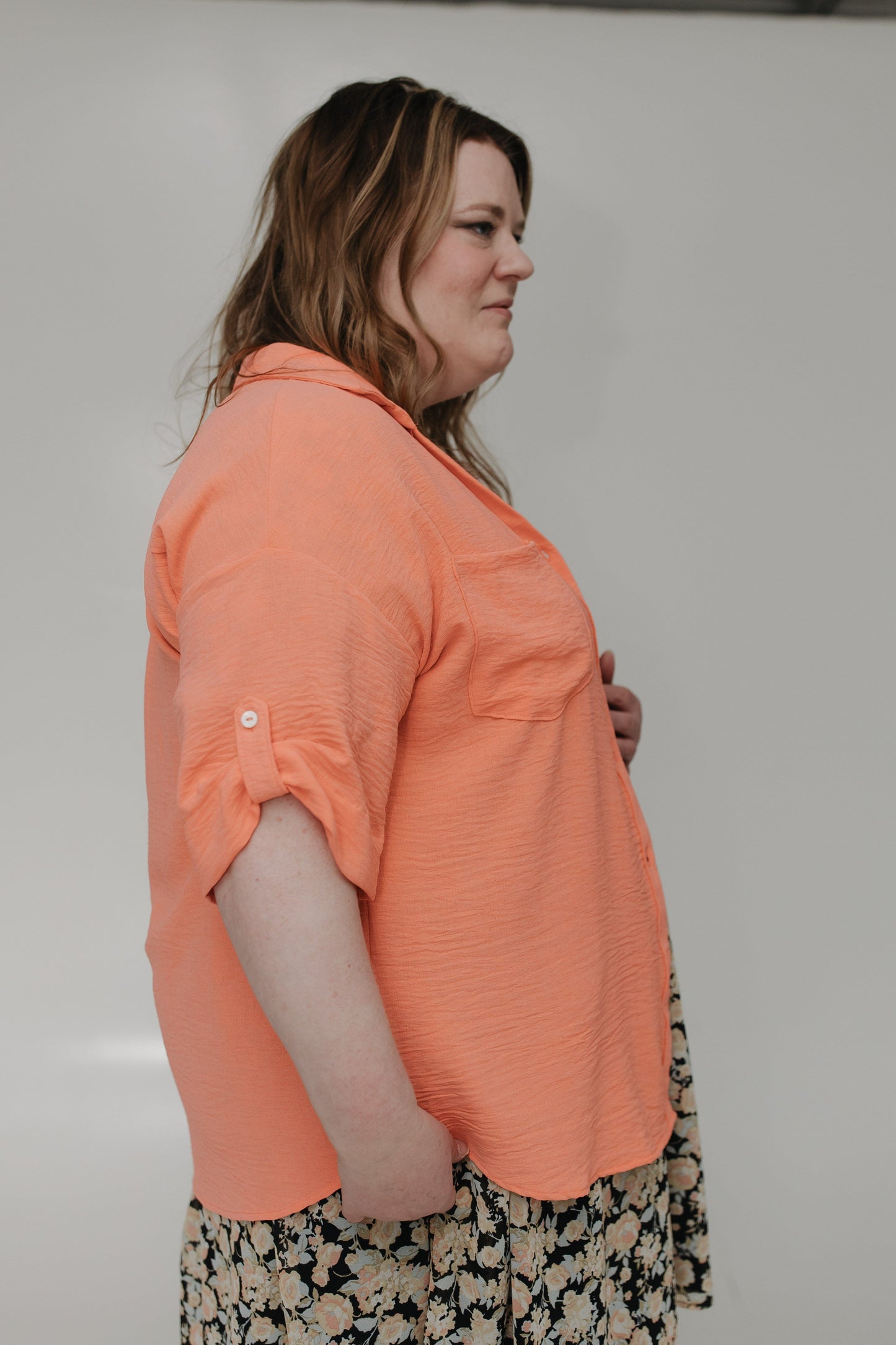 Woman wearing an orange shirt with a neutral background