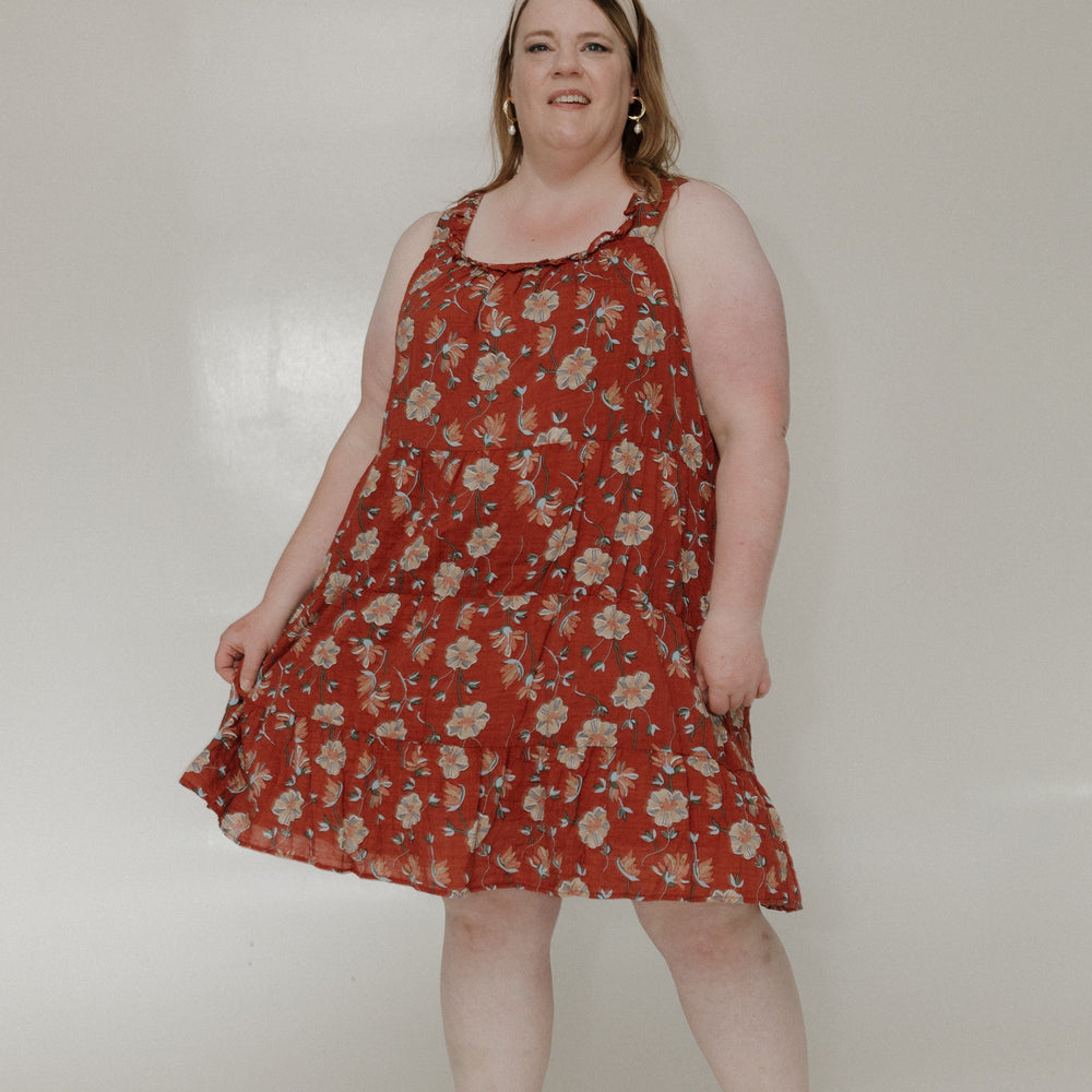 Woman wearing a red floral dress against a white background