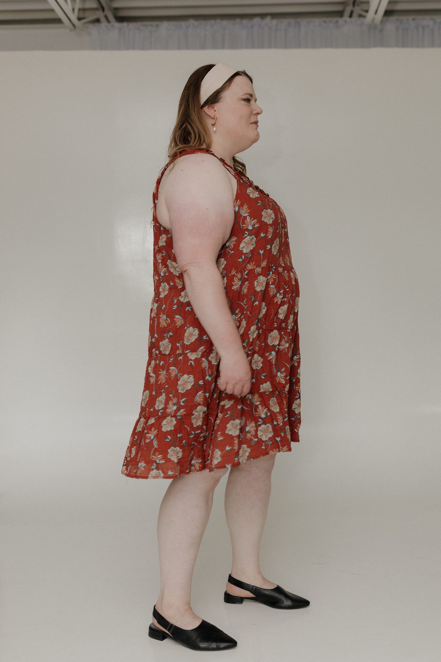 Woman wearing a red floral dress against a white background