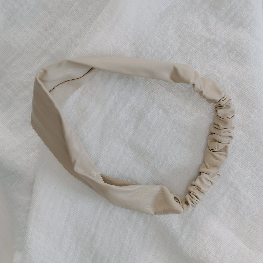Sand headband on a textured white fabric background