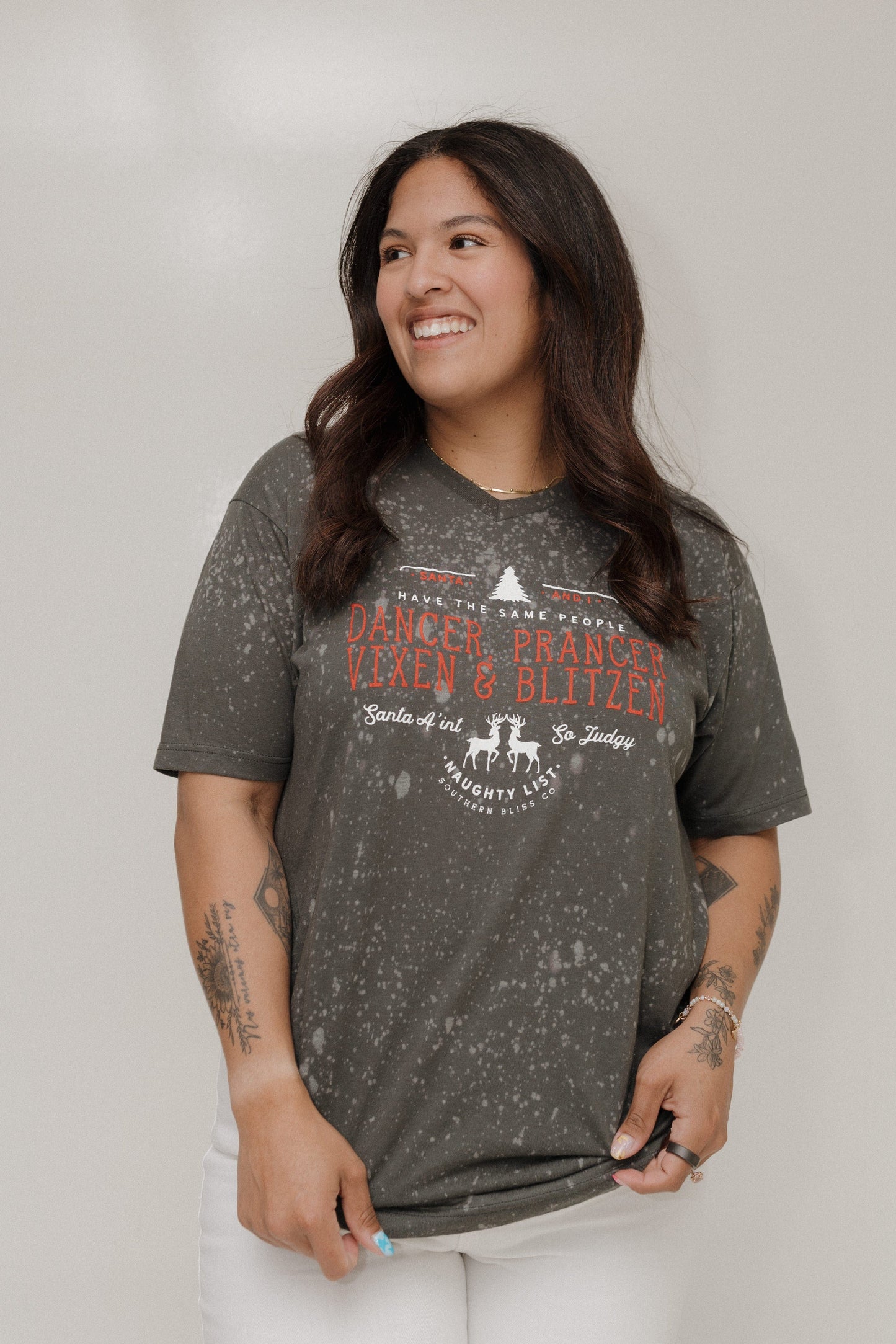 Woman wearing a gray t-shirt with text and graphics on a plain background