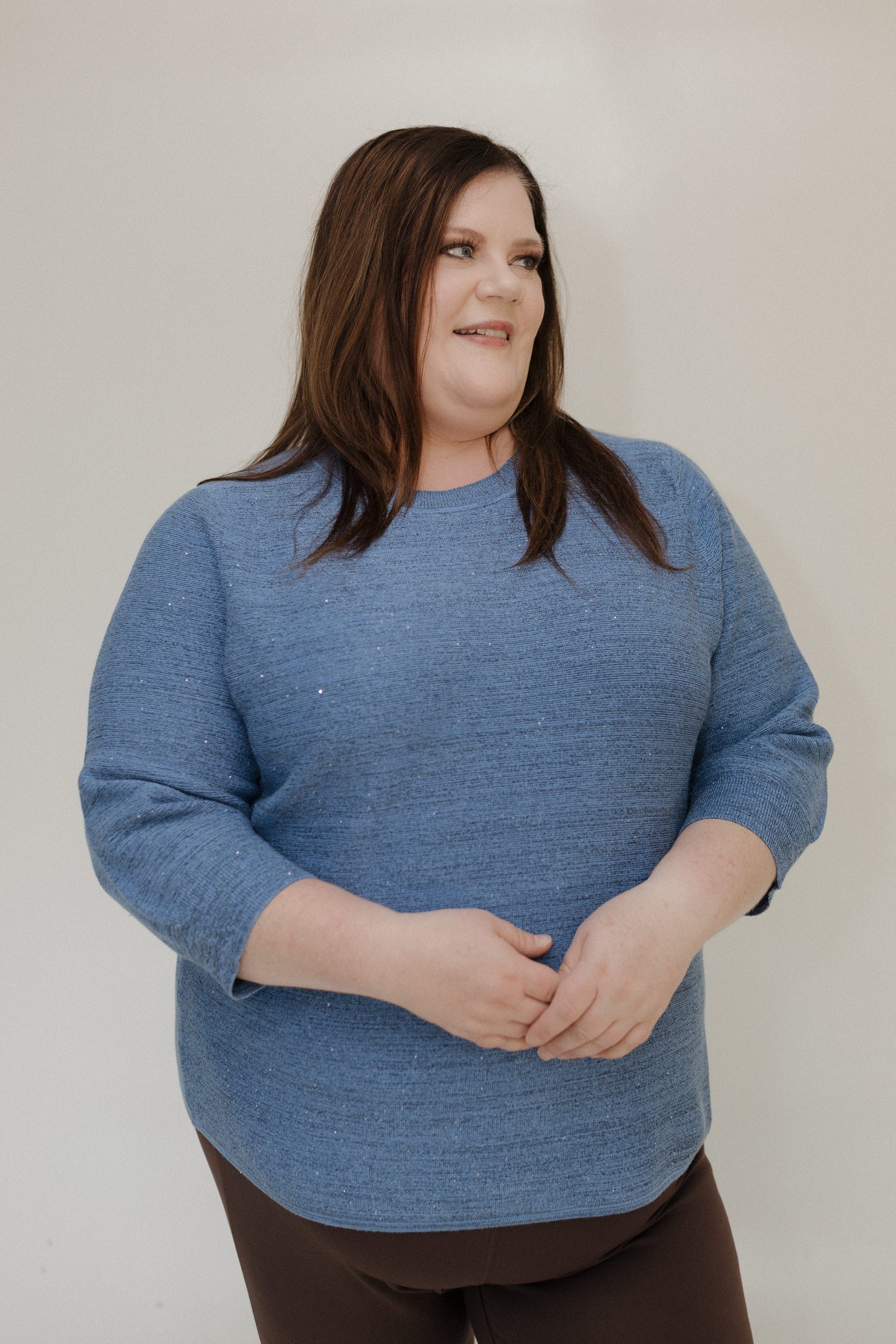 Woman wearing a blue sweater against a plain background
