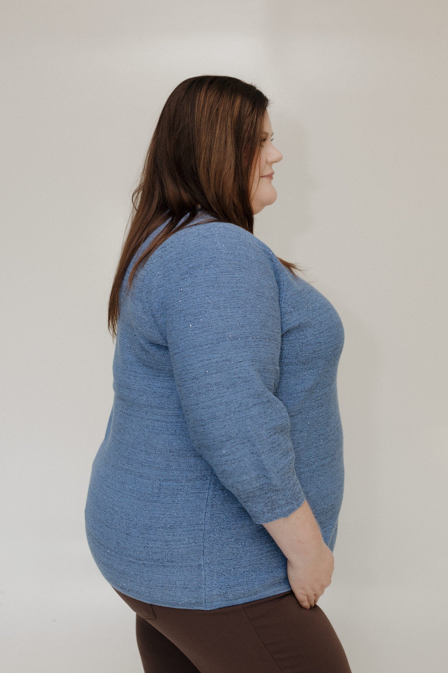 Woman wearing a blue sweater against a plain background