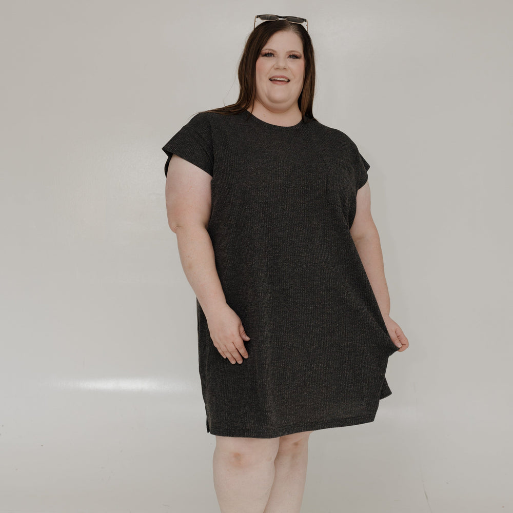 Woman wearing a black dress standing against a white background