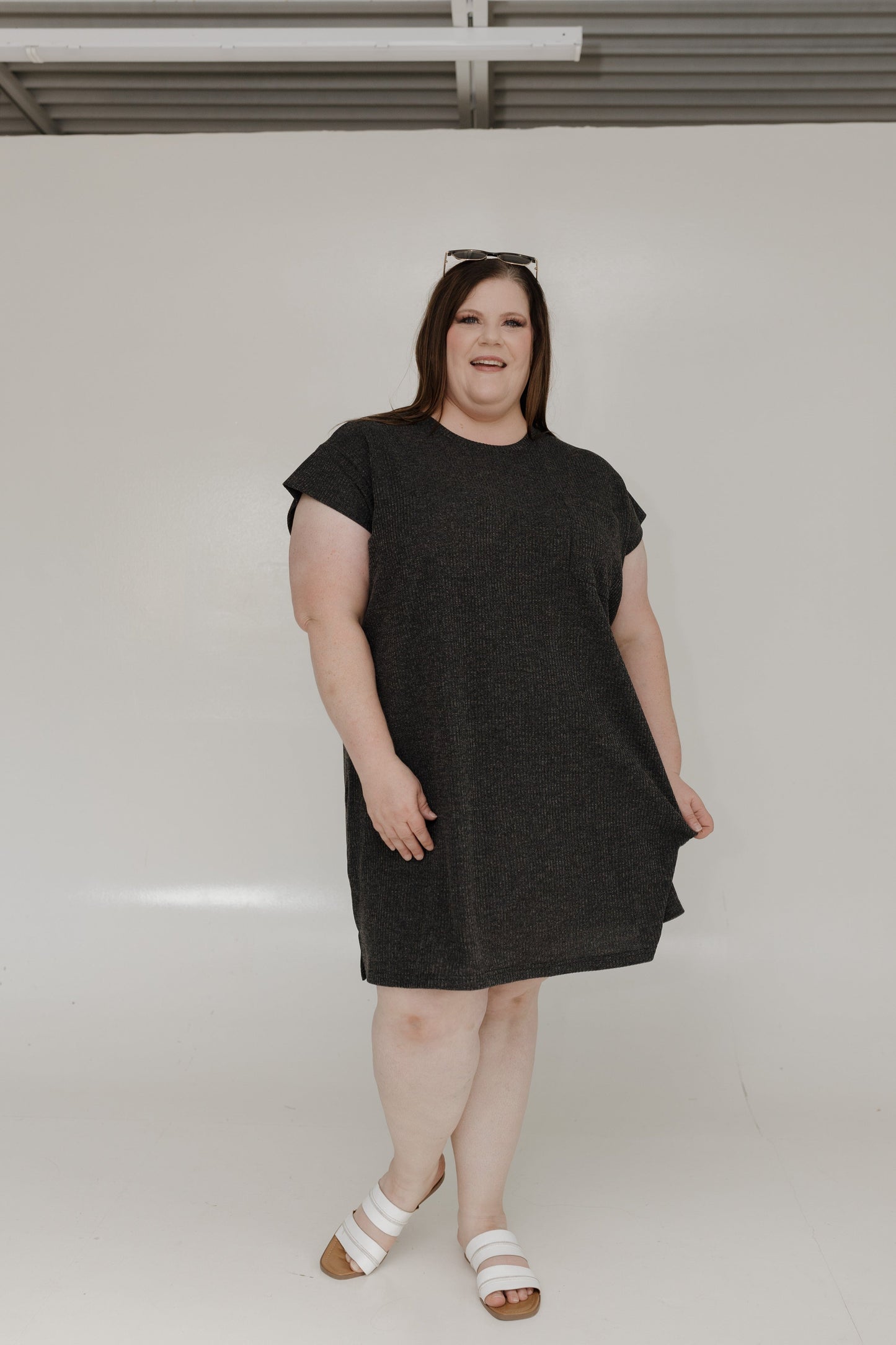 Woman wearing a black dress standing against a white background