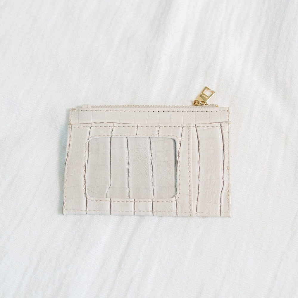 You'll never lose this wallet in your purse! The bone color and croc pattern of this wallet is super fun! Plus, so much room for your cards and cash! It has a zip closure and supple faux leather. It is RFID protected! You will be protecting your personal data with the use of RFID blocking technology! A metal fiber mesh creates a "cage" around the chip on credit cards that radio waves cannot penetrate! Protect yourself and look cute all at the same time!