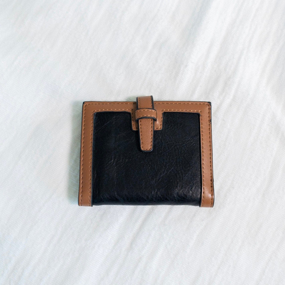 The classic color combination of black and tan is a staple for your purse collection! Plus, so much room for your cards and cash! It has a slip closure and supple faux leather. 