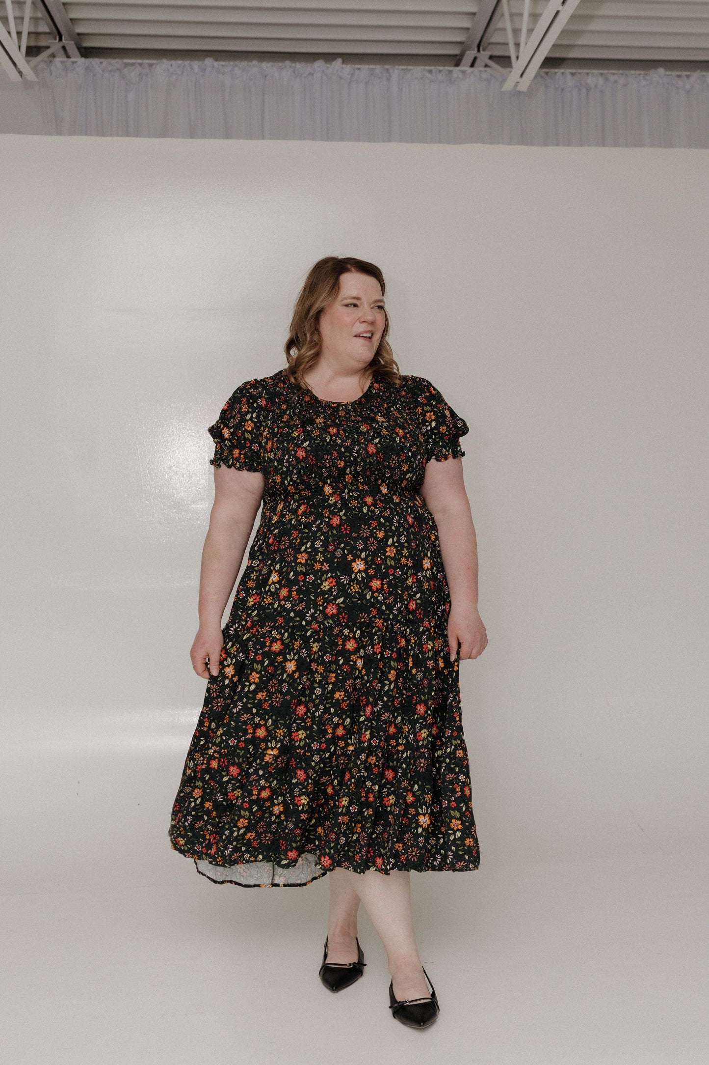 Woman wearing a floral dress against a plain background