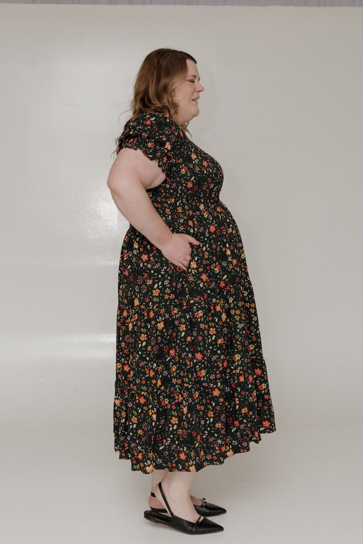 Woman wearing a floral dress against a plain background