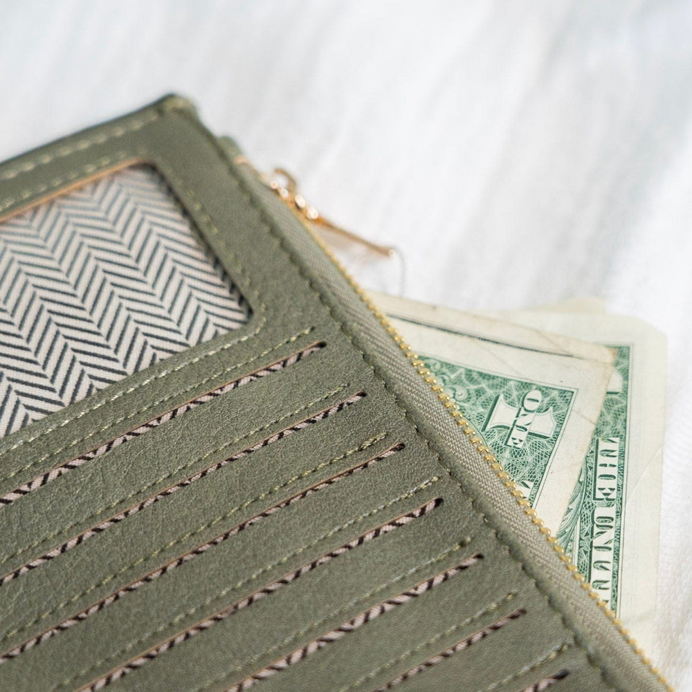 You'll make a statement with this army green wallet! This album style wallet has so much room for your cards and cash! It has two zipper pockets with a snap to keep the wallet closed. It is RFID protected! You will be protecting your personal data with the use of RFID blocking technology! A metal fiber mesh creates a "cage" around the chip on credit cards that radio waves cannot penetrate! Protect yourself and look cute all at the same time!