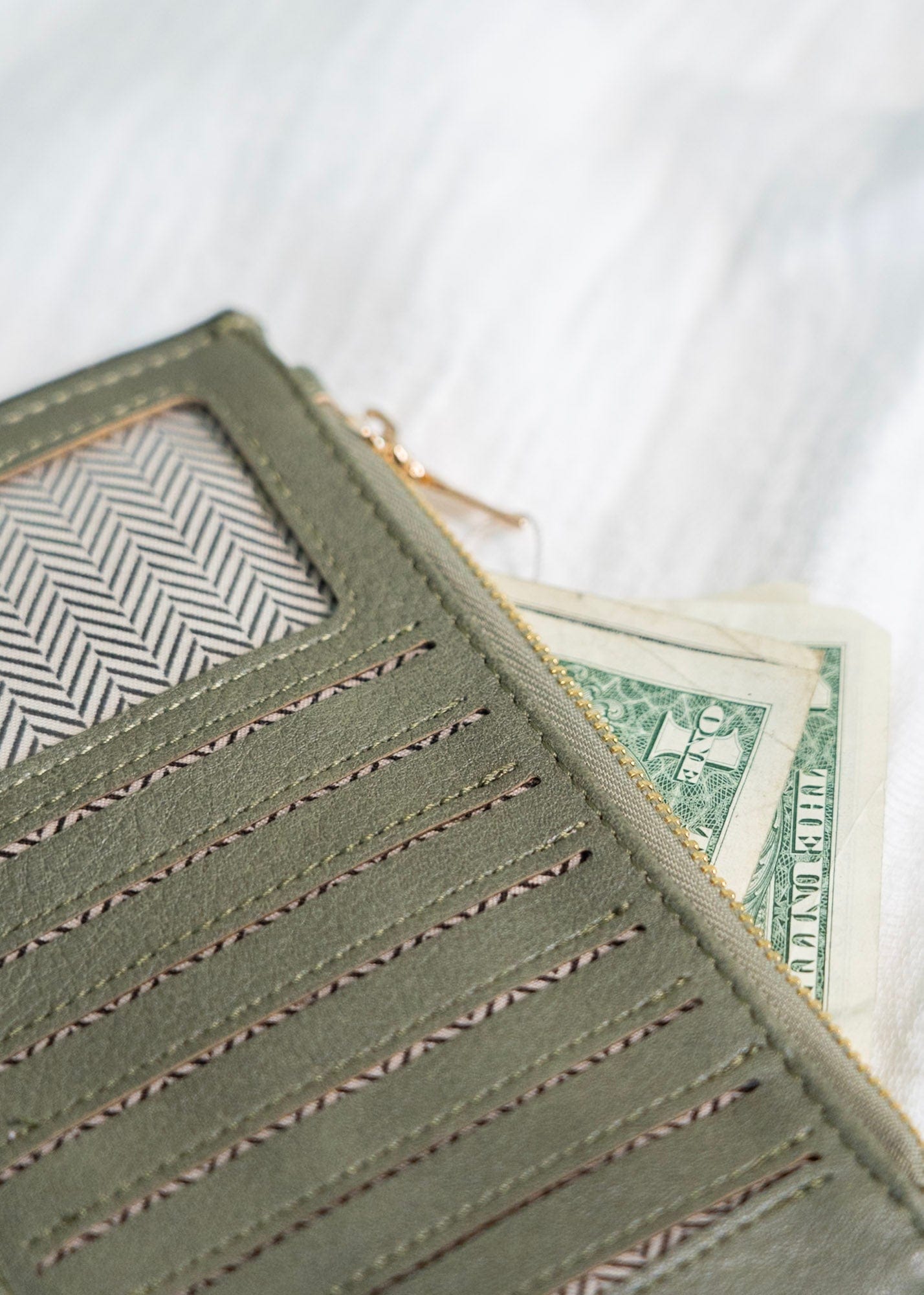 You'll make a statement with this army green wallet! This album style wallet has so much room for your cards and cash! It has two zipper pockets with a snap to keep the wallet closed. It is RFID protected! You will be protecting your personal data with the use of RFID blocking technology! A metal fiber mesh creates a "cage" around the chip on credit cards that radio waves cannot penetrate! Protect yourself and look cute all at the same time!