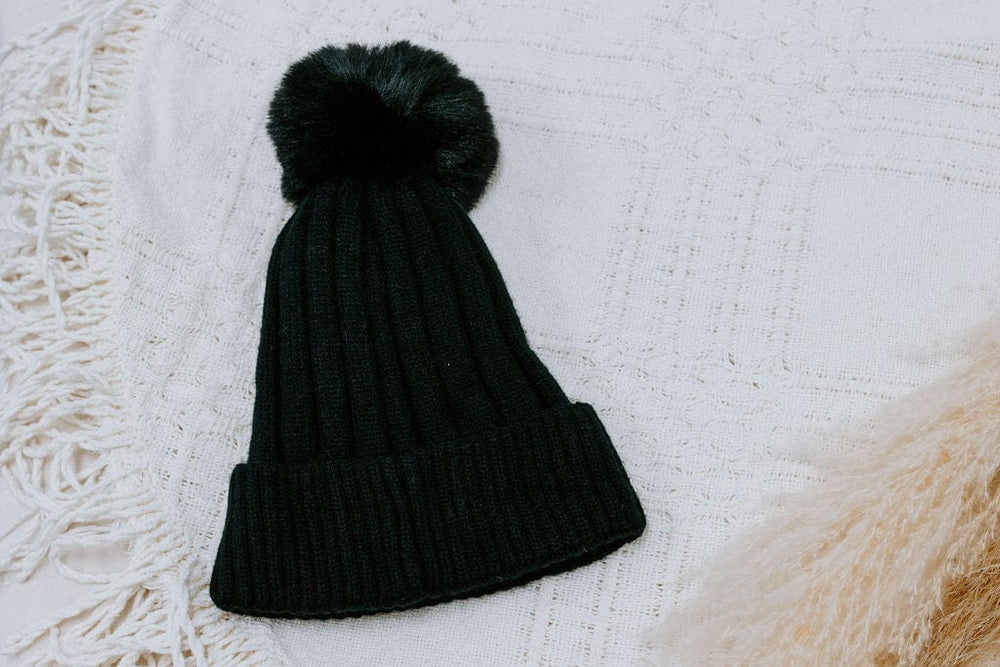 SOLID RIBBED KNIT BEANIE WITH PUFF IN BLACK