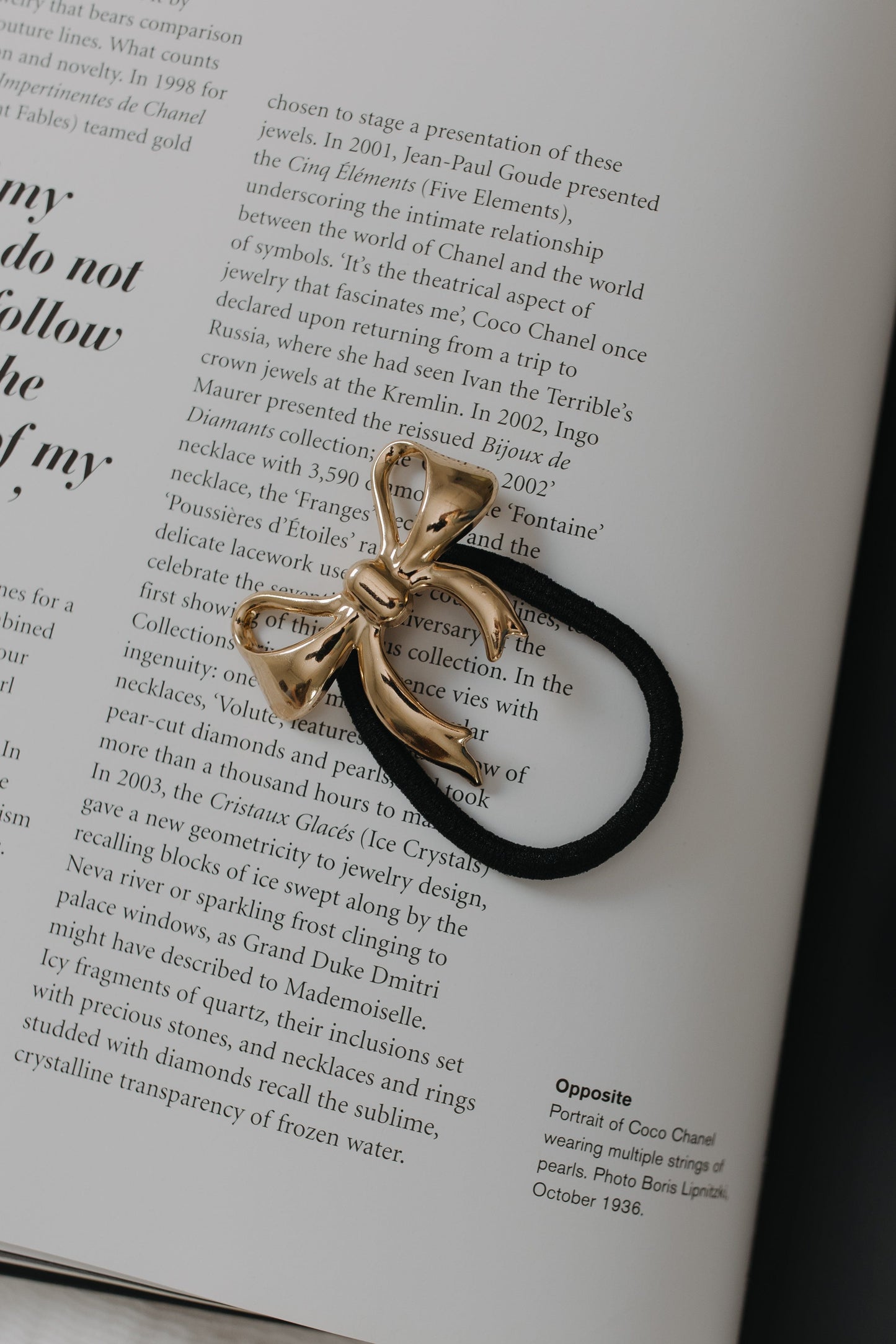 Gold bow-shaped hair tie on an open book