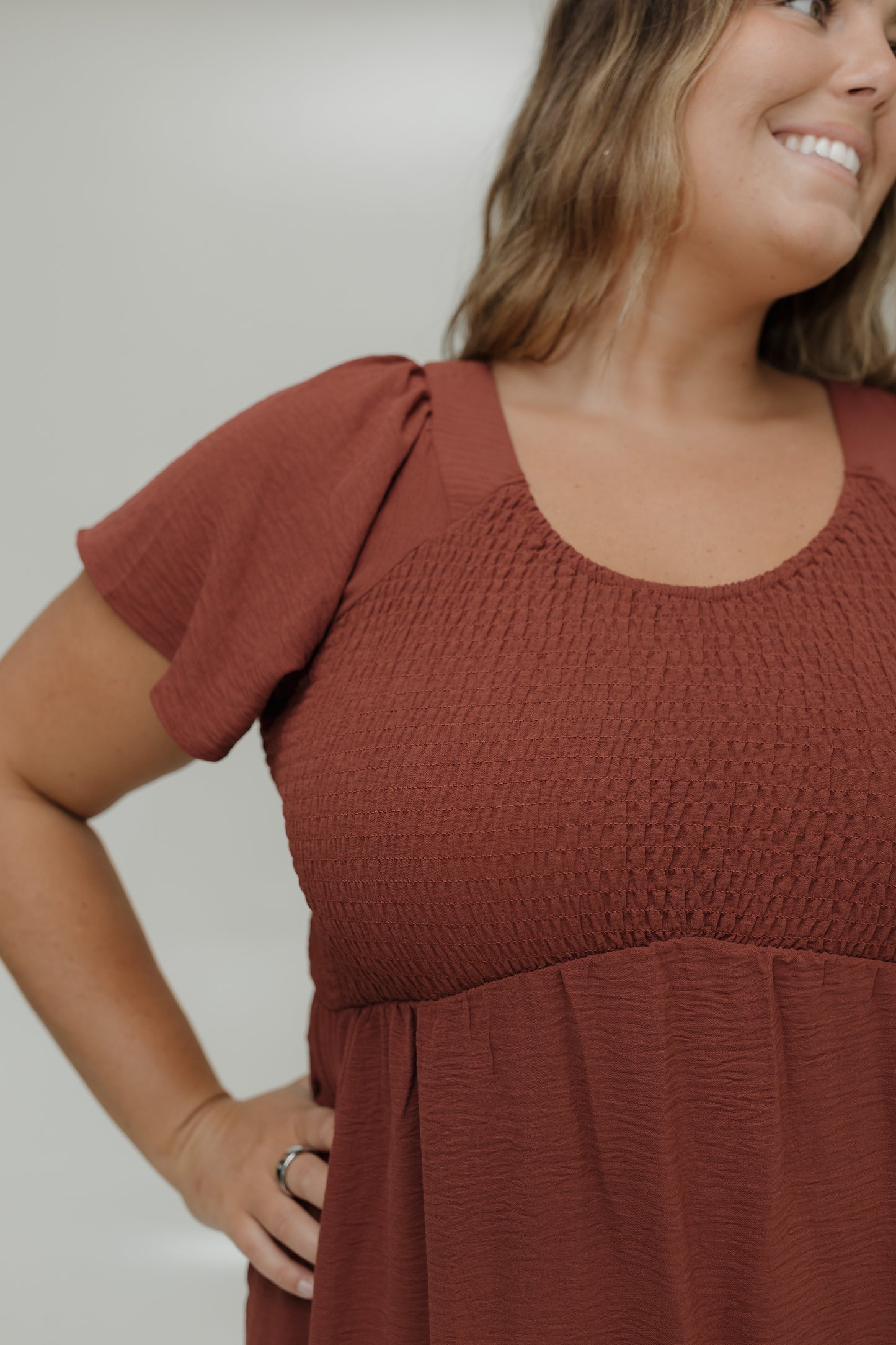 Woman wearing a brown dress with a plain background