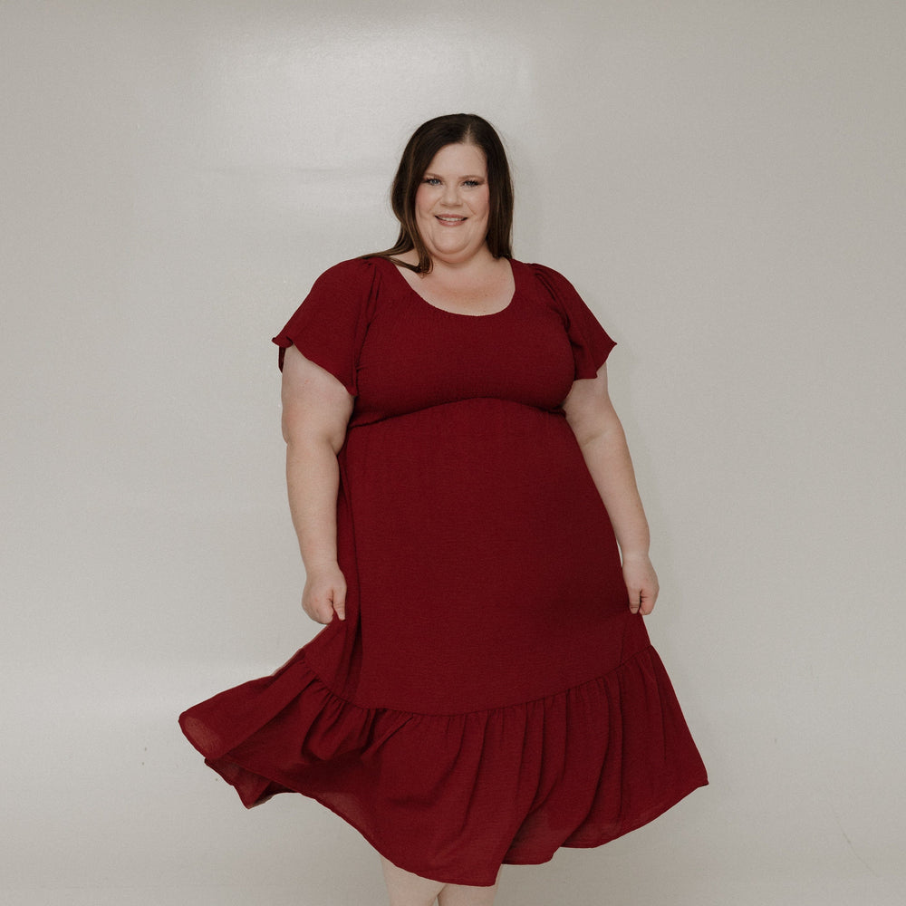 Woman wearing a red dress against a plain background