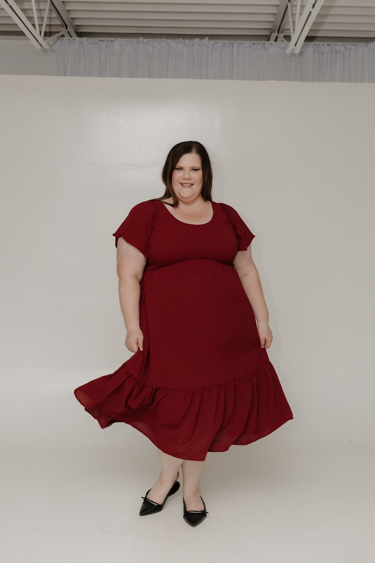 Woman wearing a red dress against a plain background