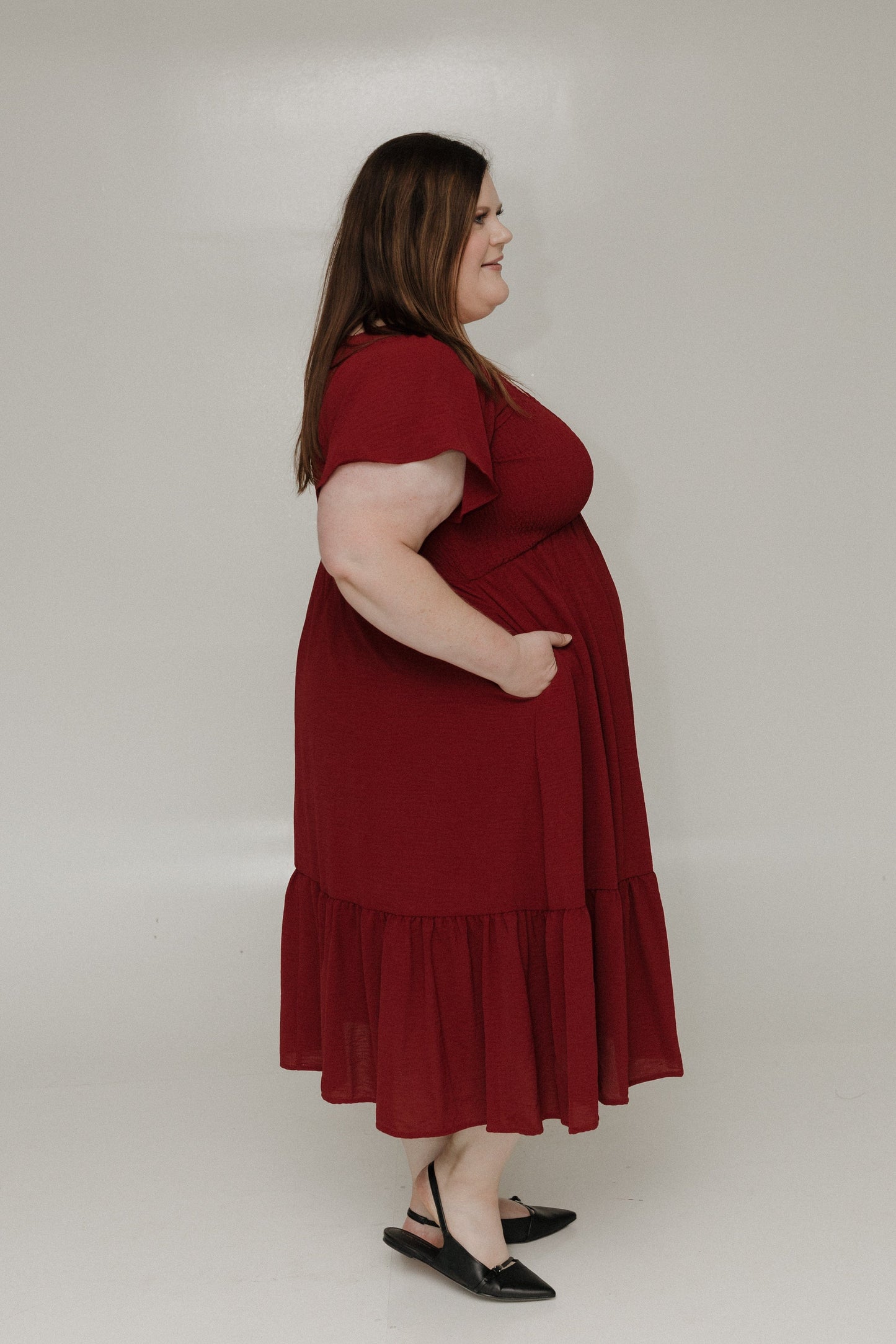 Woman wearing a red dress against a plain background