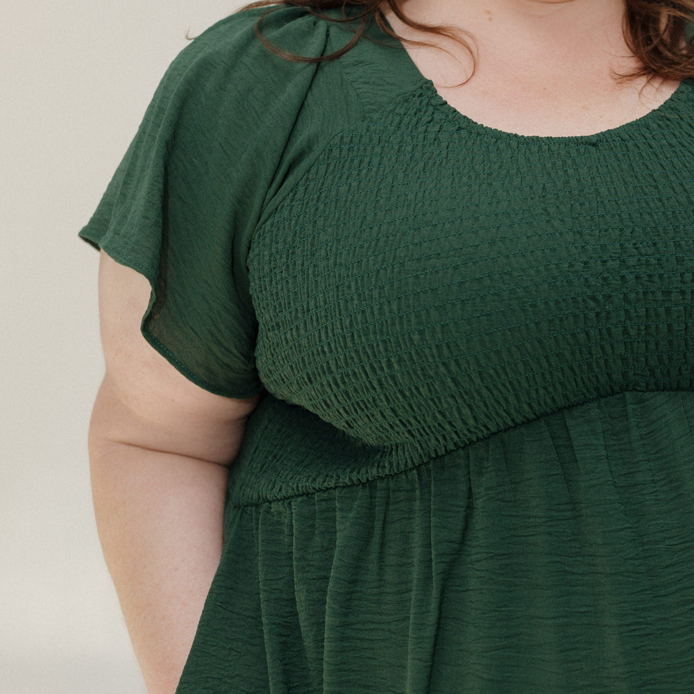 Woman wearing a green dress against a plain background