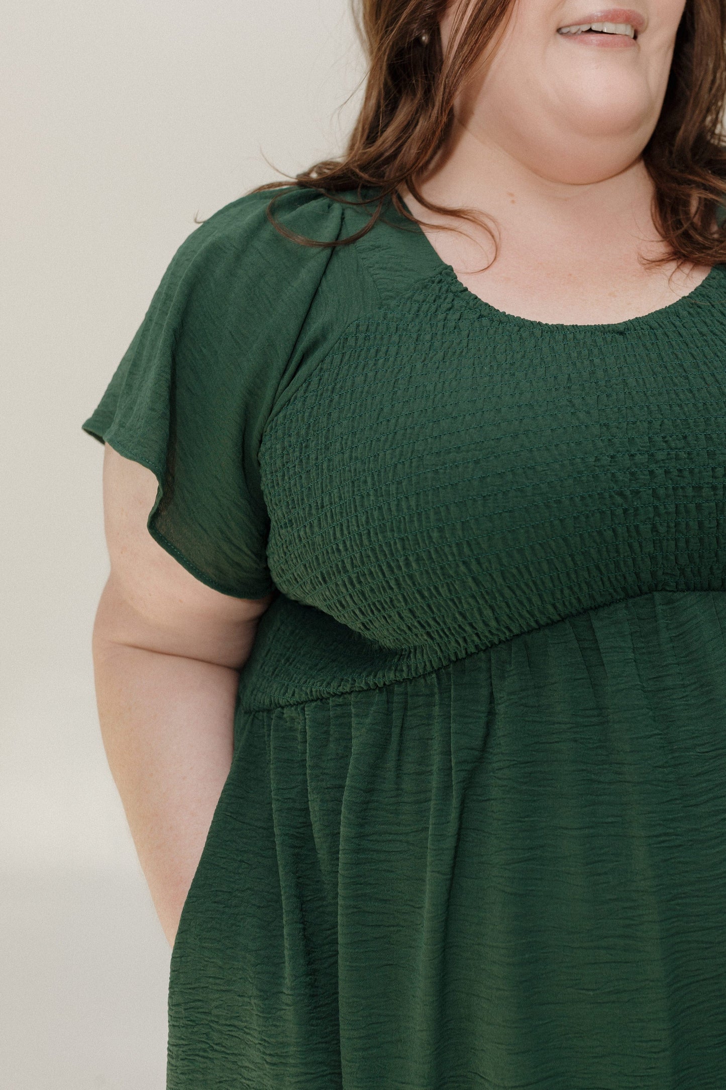 Woman wearing a green dress against a plain background