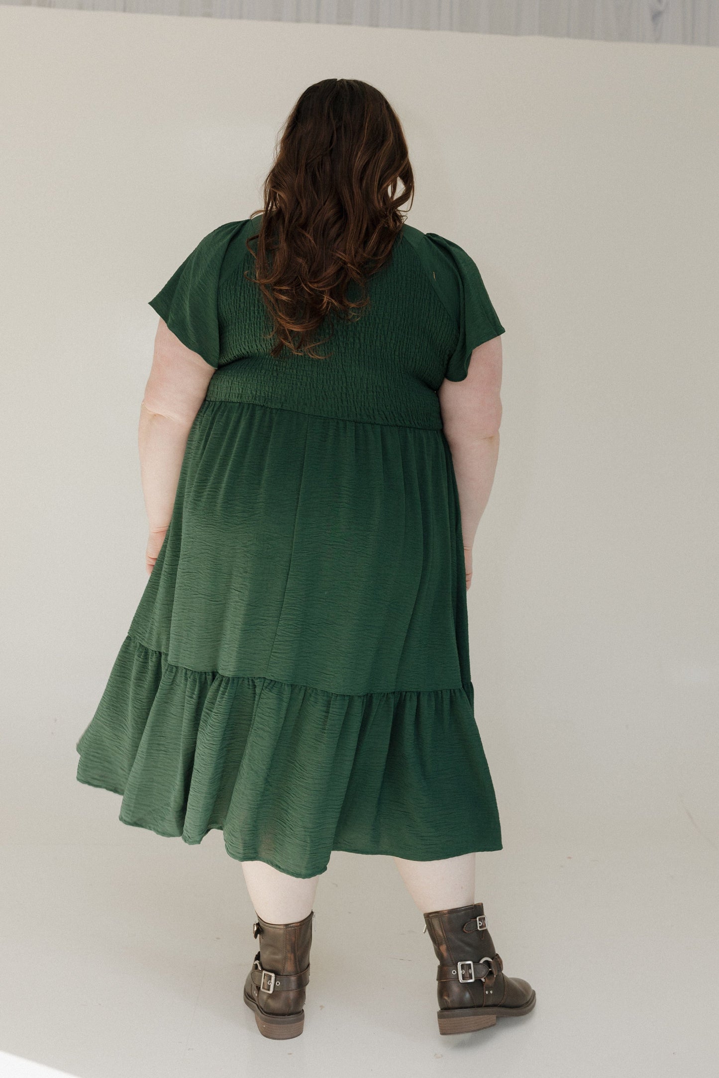 Person wearing a green dress with a plain background