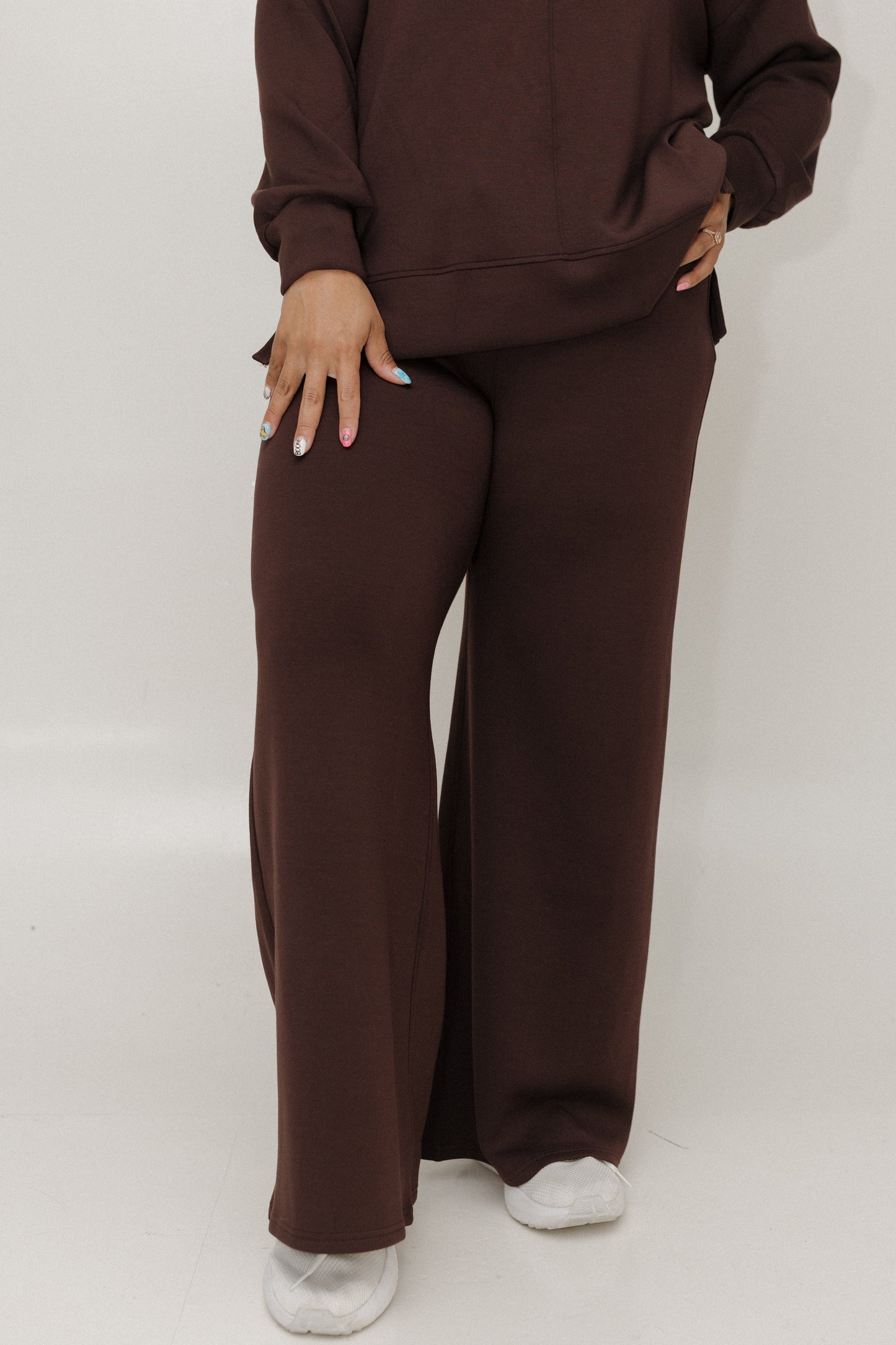 Person wearing a brown tracksuit on a white background