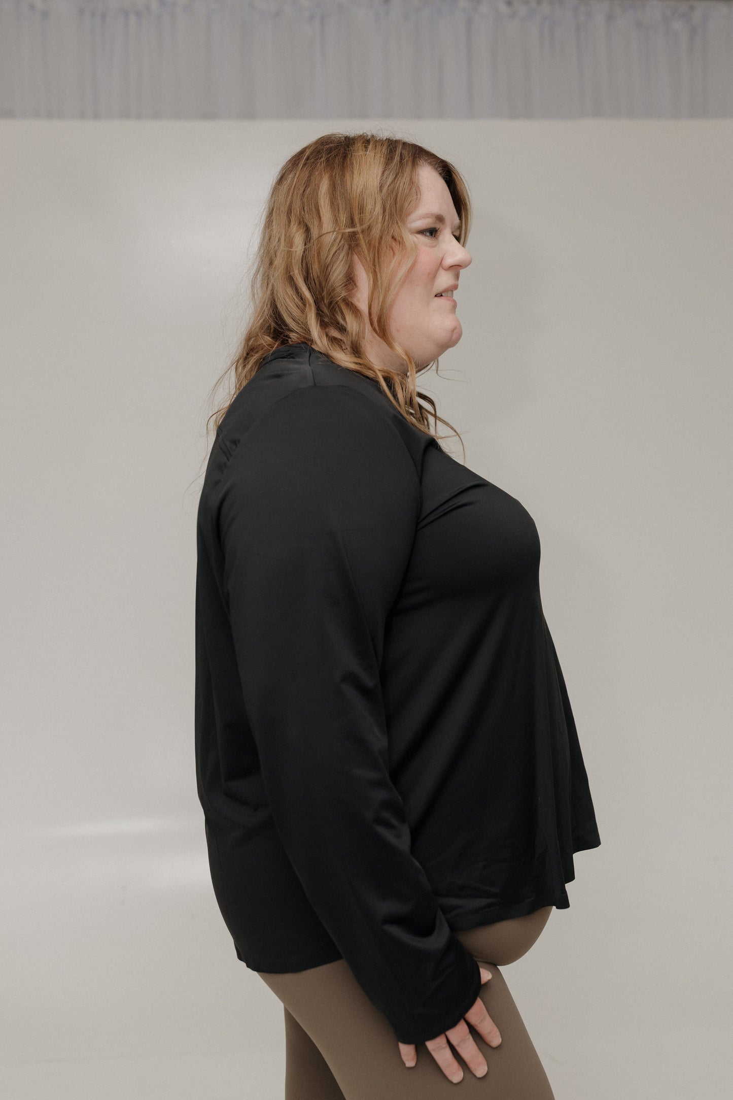 Woman wearing a black outfit against a plain background