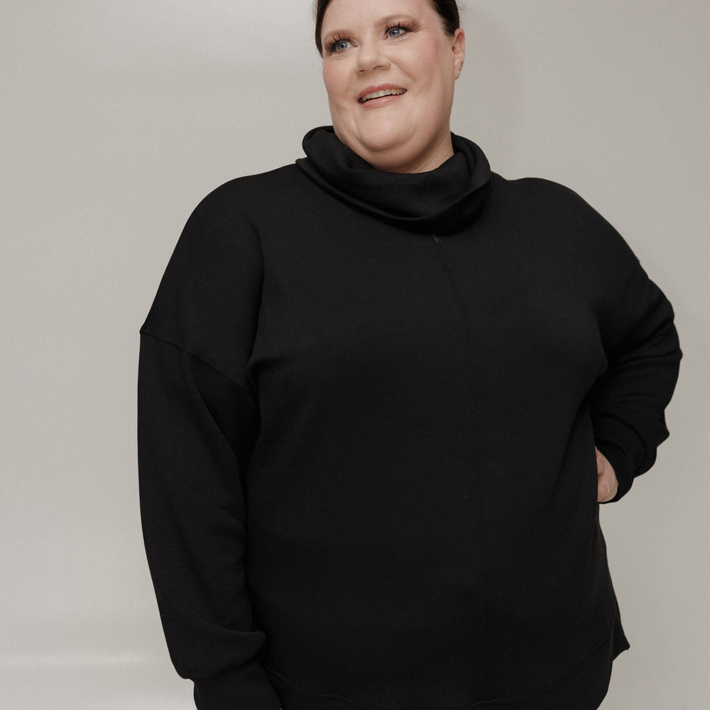 Person wearing a black outfit against a plain background