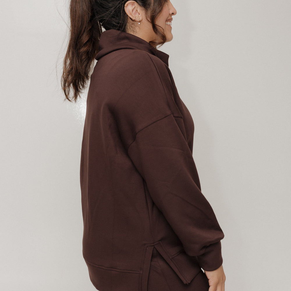 Person wearing a brown tracksuit against a plain background